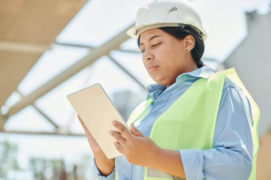 A contractor using a digital tablet at the project site.